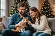 Smiling couple petting cat on sofa near christmas tree at home