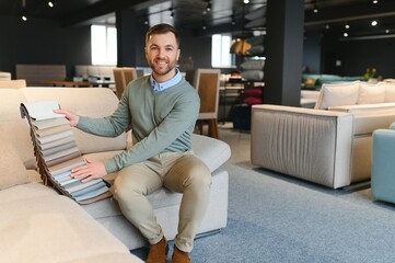 Wall Mural - Young man buying sofa in furniture store