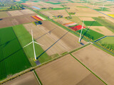Fototapeta  - Fields and wind turbines. A wind generator on the  field. View from drone. Green energy production. Landscape from air at the day time. Photo for wallpaper and background.