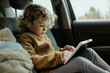 Young Girl Engaged with Tablet While Riding in Car