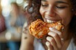 Detailed close-up of a woman munching on a crispy, golden-brown fried chicken drumstic