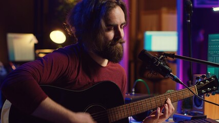Poster - Artist with condenser microphone composing a song on guitar, working on mixing and mastering music. Producer recording tunes and adding sound effects in post production. Camera A.