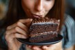 Macro shot of a woman relishing a slice of moist, decadent chocolate cake