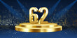 62nd Year anniversary celebration background. Golden 3D numbers on a golden round podium, with lights in background.