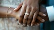 Two hands one with a delicate engagement ring hold onto each other tightly symbolizing the deep connection between a newly engaged couple. .
