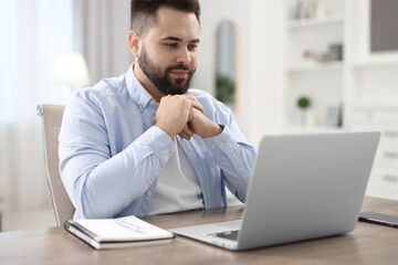 Poster - Young man watching webinar at table in room