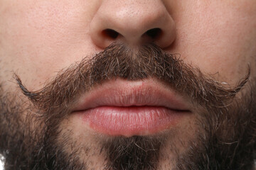 Wall Mural - Young man with mustache on white background, closeup