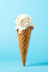 Wall Mural - Vanilla ice cream served in a waffle cone on a light blue surface