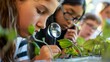A closeup shot of a student using a magnifying glass to examine a leaf while their classmates gather around to learn about the types of plants that can be used to produce biofuel. .