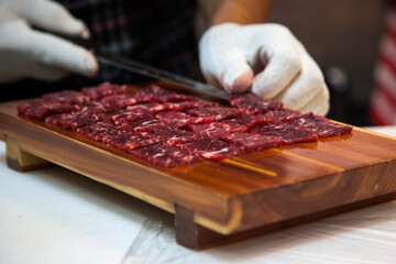 preparing the beef sashimi on the wooden board