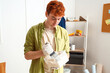 Young man with putty knife and plaster working at home