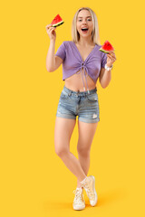 Wall Mural - Beautiful young woman with slices of fresh watermelon on yellow background