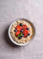 Wall Mural - oatmeal porridge with strawberries blueberries and honey