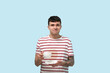 © Pixel-Shot - Confused young man with stains on his striped t-shirt on blue background