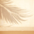 Selective focus.sandstone top product display platform in tropical design with shadow palm leaf on beige pastel wall