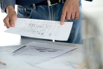 Poster - Engineers and architects are looking at the plans of the construction project consulting to plan the