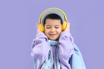 Sticker - Cute little Asian boy in adult clothes with headphones on lilac background, closeup