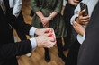 © Aleksey - A man in formal wear shares a playing card gesture with a group at an event