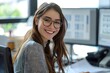 © Alejandra - Mujer con lentes y pelo negro largo sonriendo, sentada frente a la computadora. Mujer feliz en el trabajo