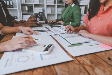 Wall Mural - Teamwork process The Business team uses a calculator to calculate figures, business statistics, profit, cost analysis, and growth rate graph documents. data charts on the desk.