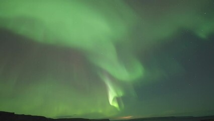 Wall Mural - Mesmerizing northern lights dance above a tranquil fjord on a dark winter night. A timelapse video.
