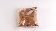 Cocoa powder in a transparent bag on a white background.