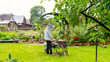 Woman at the barbecue under a canopy frying barbecue in the rain. Rainy weekend in the country. Concept summer, cottage, barbecue. A rainy day at a dacha in the suburbs of Moscow.