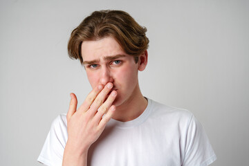 Young Man With Hand Over Mouth Showing Signs of Regret or Shock