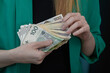 Bizneswoman trzyma w ręce banknoty w dużych nominałach 