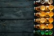 Beer bottles and beer glasses on black wooden background,  Top view