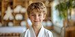 © Mr. Stocker - A young boy is smiling and wearing a white karate uniform
