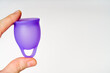 Female Hands with Violet Menstrual Cup: Blank Area on White Backdrop