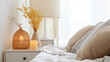 A cozy soft white bed with a bedside a close-up in daylight