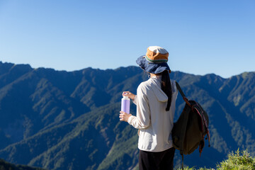 Canvas Print - Sport woman enjoy the mountain and hold with water bottle