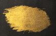 Golden paint foil brush stroke on black.
