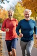 © Stavros - Positive senior man and his young son run together across autumn park in morning. Healthy father and offspring exercise jogging along city garden road. Active family trains developing body endurance