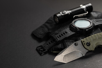 Wall Mural - Everyday carry EDC items for men in black color - flashlight, watch and knife. Survival set. Minimal concept