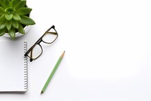 An Open Notepad With Glasses And A Green Plant On Top