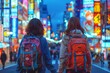 two girls in backpacks walk down a busy street at night