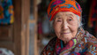 A Chinese old woman with a colorful hat and a red and white jacket. She is smiling and looking at the camera. A kind Chinese old lady with a kind smile