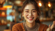 © Nataliia_Trushchenko - A Korean woman with glasses is smiling and looking at the camera. She is wearing a brown sweater and has her hair in a ponytail. A Korean woman in her mid-30s, wearing nice glasses, calm smiling