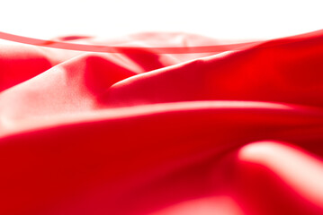 Wall Mural - The bright red silk satin surface is beautiful and luxurious, wavy. For background and graphic work Blurry or blurry