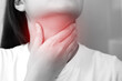 sore throat pain. Closeup of young woman sick holding her inflamed throat using hands to touch the ill neck in blue shirt on gray background. Medical and healthcare 