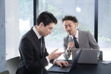 Wall Mural - Senior male businessman company employee gently instructing junior employees, training new employees and mentoring newcomers in the company.