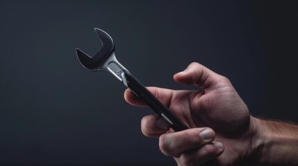 Poster - a human hand holds a black wrench and looks out over a smartphone screen. this is a concept of techn