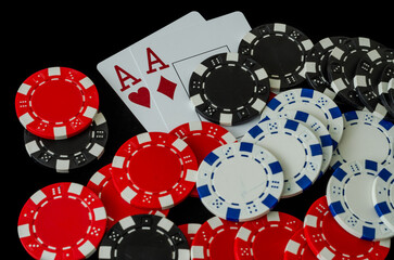 Poker chips and cards in a casino on a black background