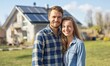 © NickArt - Happy couple young man and woman standing near their new eco friendly passive house with photovoltaic system solar panels for renewable energy on sunny day