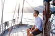 Man sailing on yacht. Young sailor alone on boat. Traveler relaxing in sea adventure. Solo summer vacation and holidays in self isolation, social distance. Mental health in transformational travel