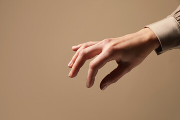 Wall Mural - woman holding something in hand on beige background, closeup