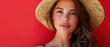 Portrait of beautiful young woman wearing summer hat on red background, blank copy space for advertising text